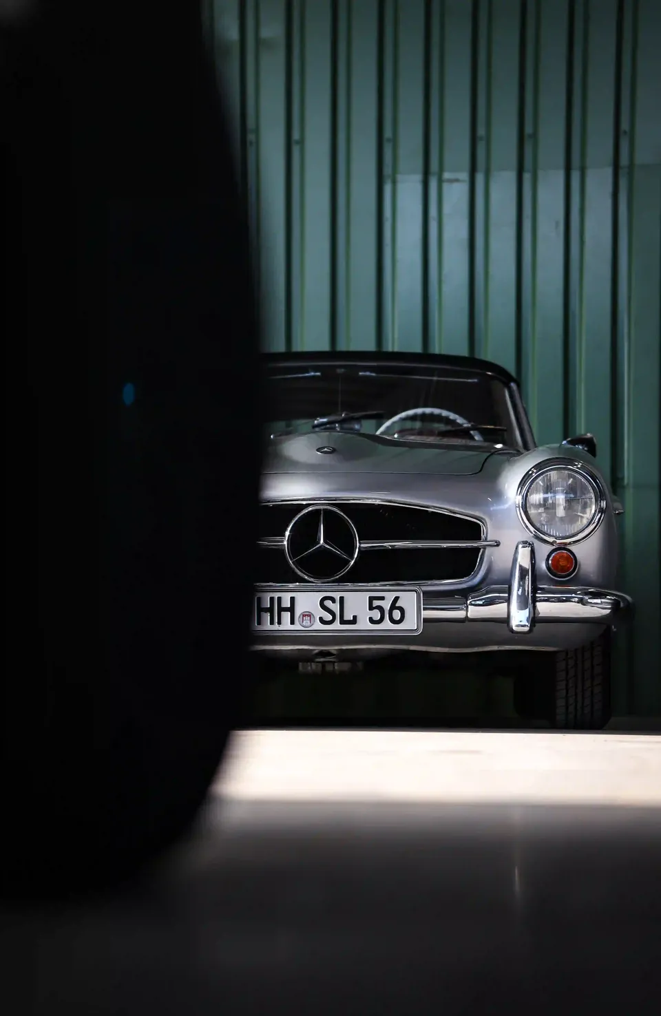Silberner Mercedes-Klassiker im seitlichen Licht einer dunklen Garage