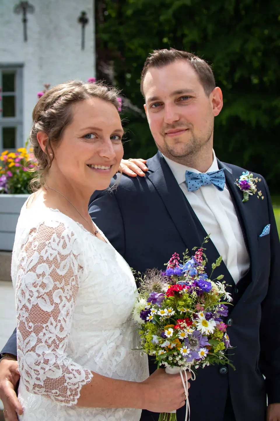 Hochzeitsportrait eines Brautpaars mit Blumenstrauß